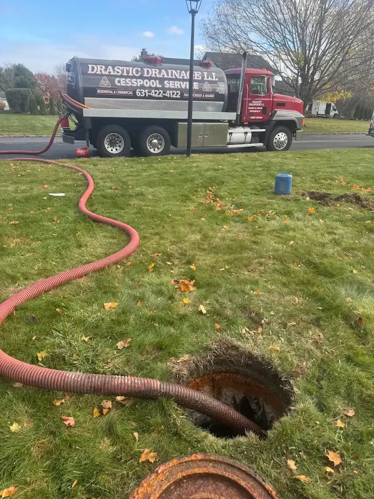 A Cesspool Service Suffolk County truck pumping sewage from an open tank in a grassy NY yard on a sunny day.